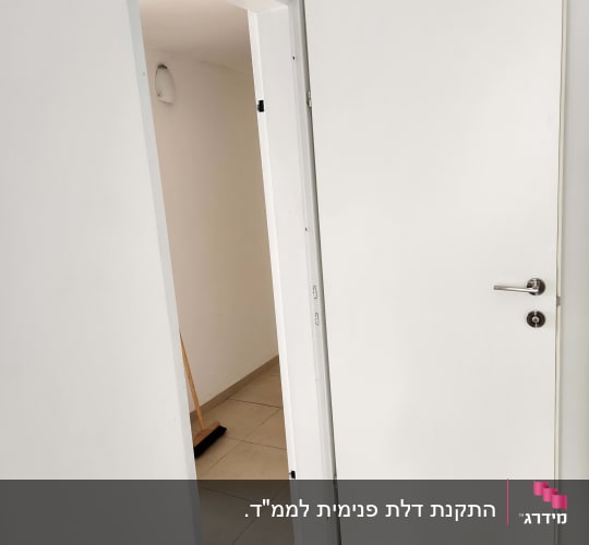 דלת לבנה פתוחה עם ידית כסופה